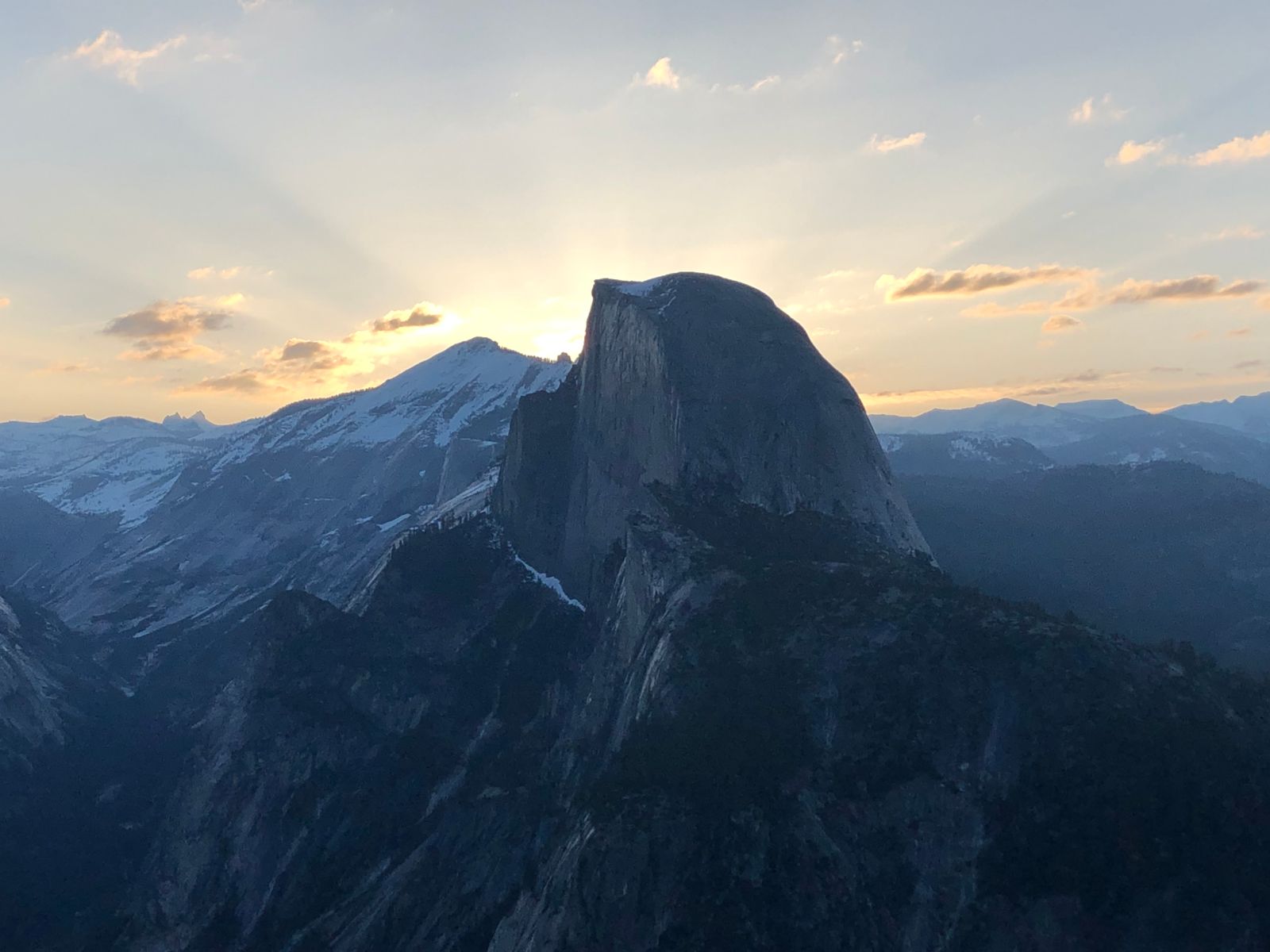 Rays of sun dart past Half Dome during sunrise